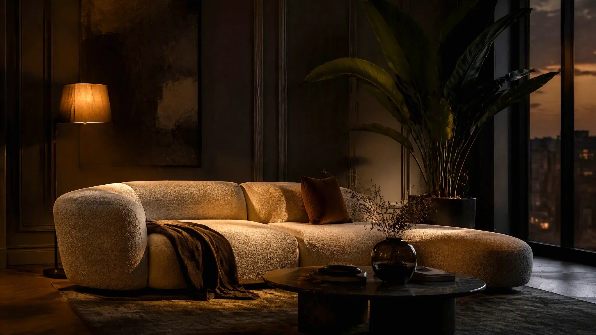 Cream sofa in a deep charcoal living room lit by warm side light